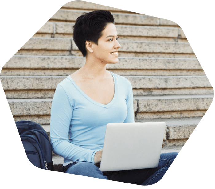 Senhora sentada nos degraus do lado de fora trabalhando em seu laptop