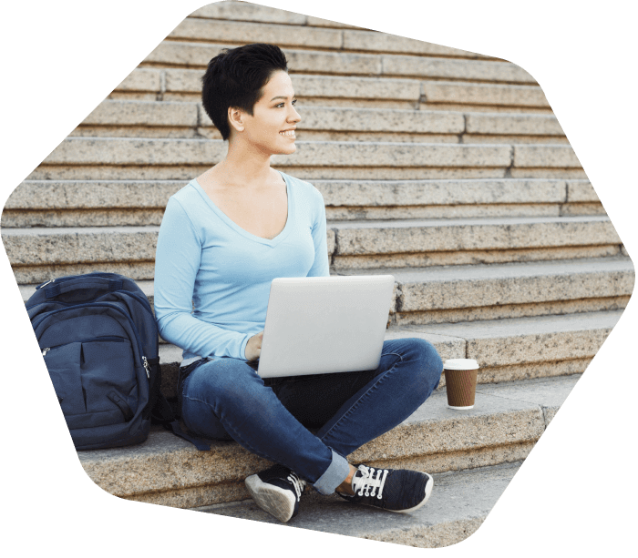 Lady sitting on the steps outside working on her laptop